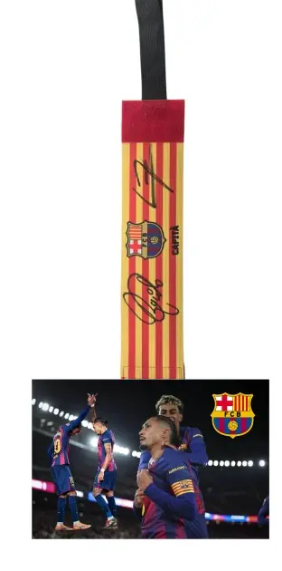 FC Barcelona captain's armband with Raphinha's signature and players celebrating on the pitch