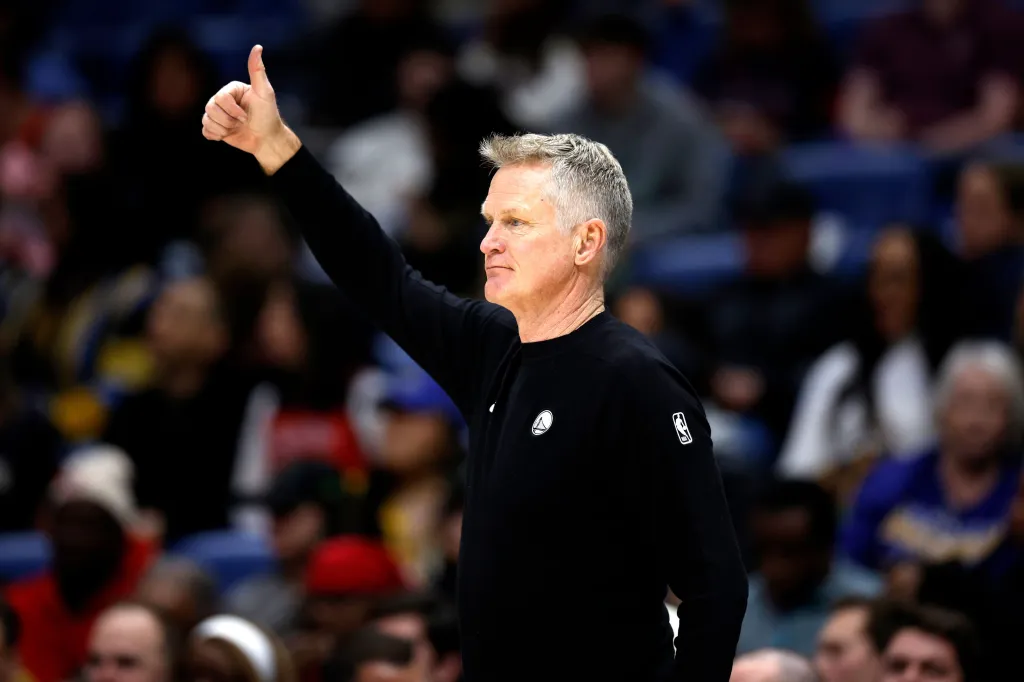 Golden State Warriors head coach Steve Kerr giving a thumbs up gesture during an NBA game.