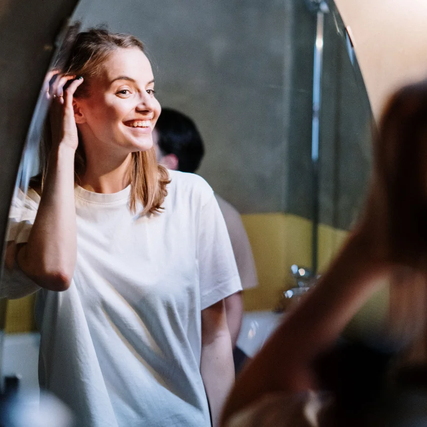 happy woman loving herself again looking in mirror