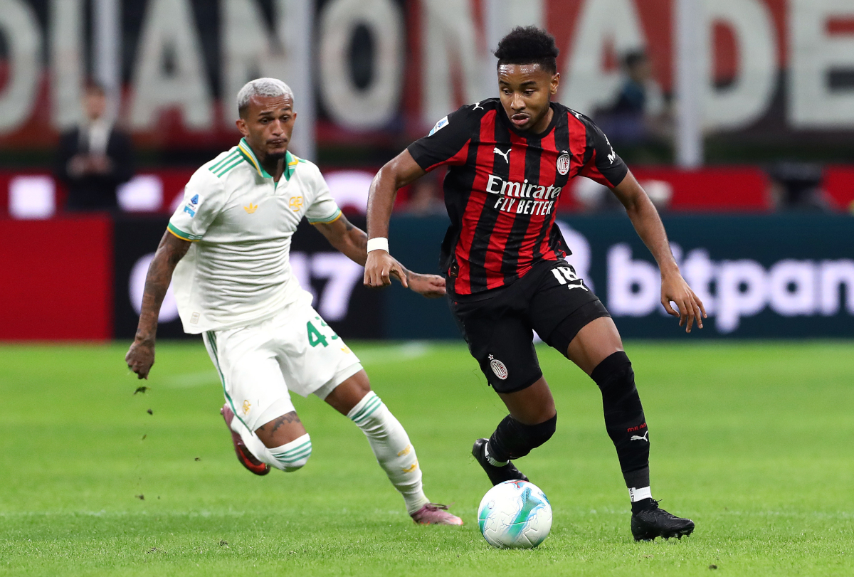 MILAN, ITALY - NOVEMBER 02: Christopher Nkunku of AC Milan runs with the ball whilst under pressure from Wesley Franca of AS Roma during the Serie A match between AC Milan and AS Roma at Giuseppe Meazza Stadium on November 02, 2025 in Milan, Italy. (Photo by Marco Luzzani/Getty Images)