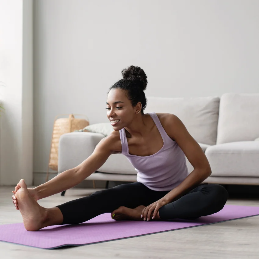 high-strung woman practicing yoga in her living room to calm down fast