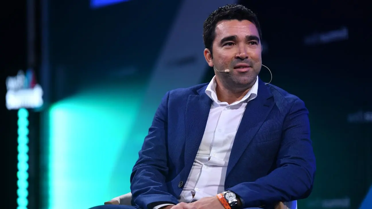 Portrait of Deco, FC Barcelona sporting director, wearing a blue blazer and white shirt with a headset microphone