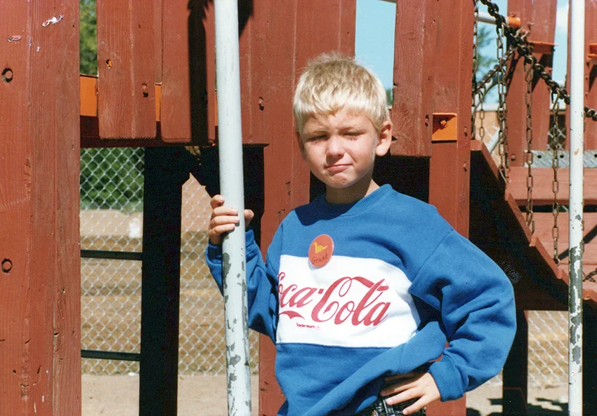 child stands alone on the playground in the 90s