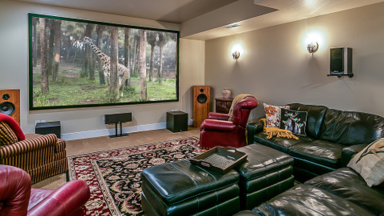 A living room with a surround sound setup that includes tower speakers, two subwoofers, a center speaker, and rear speakers
