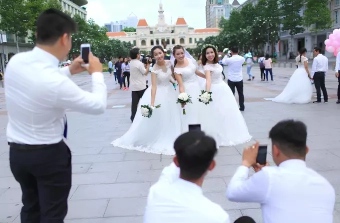Young people taking group wedding photos. Photo by Read/Viet Anh
