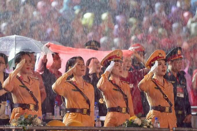 Soldiers braved the rain along with tens of thousands of people during the flag raising ceremony and singing of the National Anthem to open the concert. Photo: Thanh Tung
