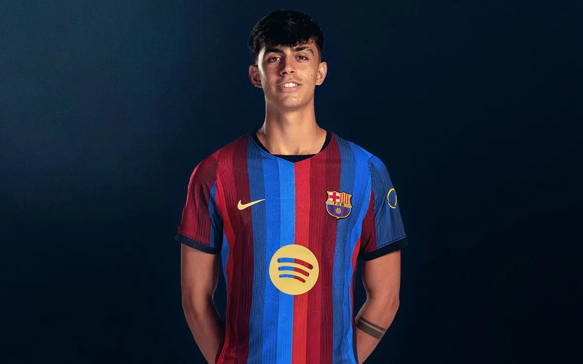 Marc Bernal posing in the FC Barcelona home kit against a dark blue background