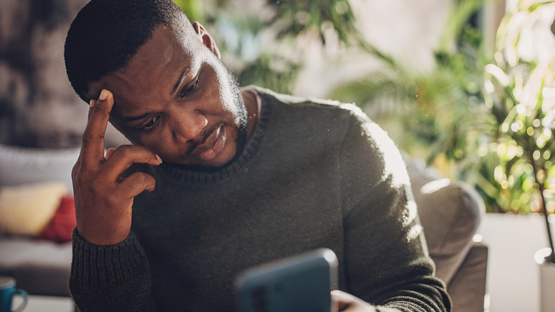 Person looking at their phone, frustrated