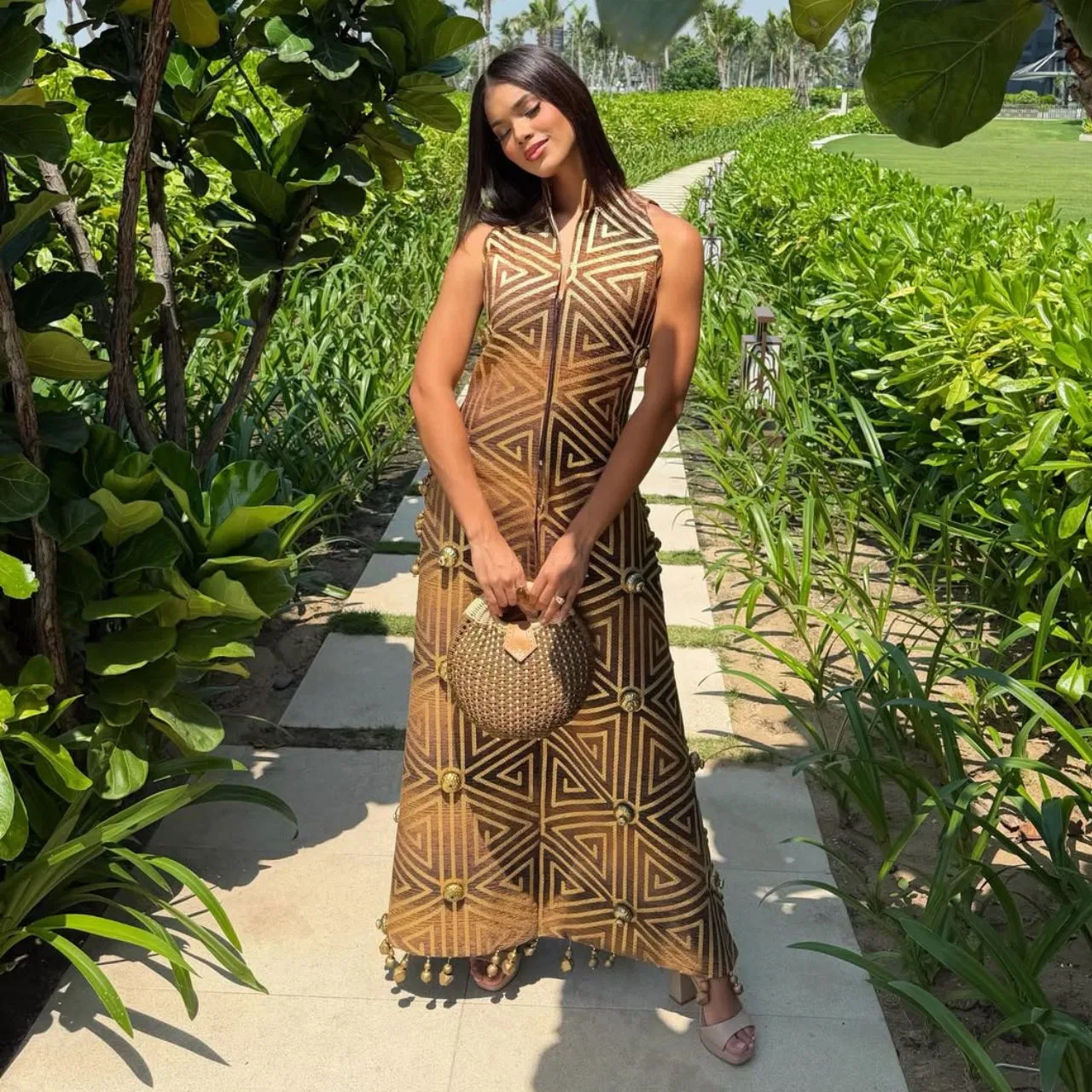 Johari Mol is seen looking elegant and classy in a geometric print dress with golden and earth color base. It has a collar neck with a fitted silhouette and the zip at the front gives it a modern touch.  From handbags, statement accessories, heels and open hair make her look even more stunning.