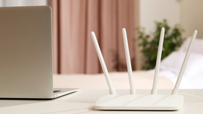 Wi-Fi router on desk next to laptop.