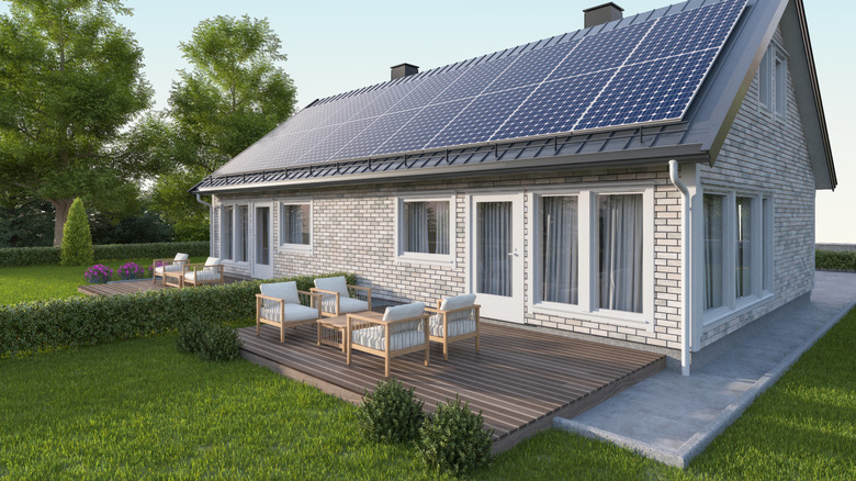 Solar panels shown on the roof of a modern white brick house