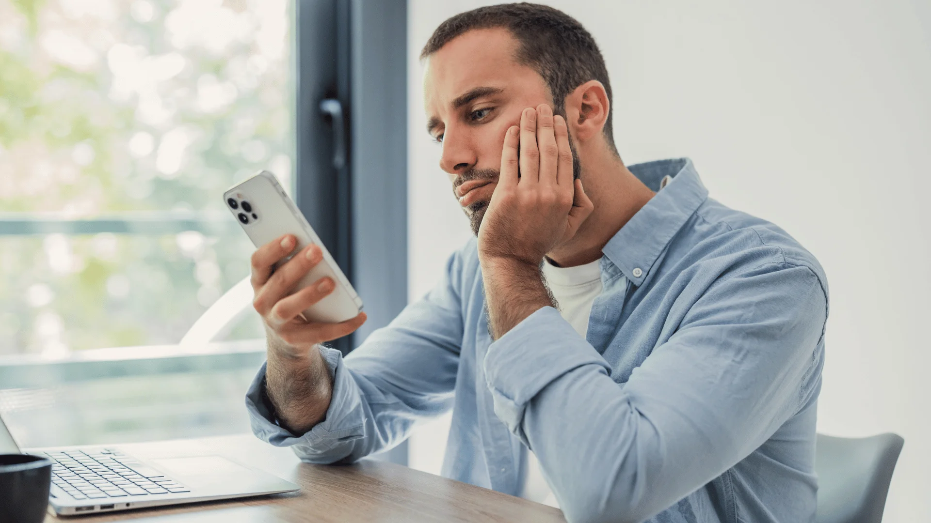 man in jean jacket staring at phone as he says there's nothing to look forward to