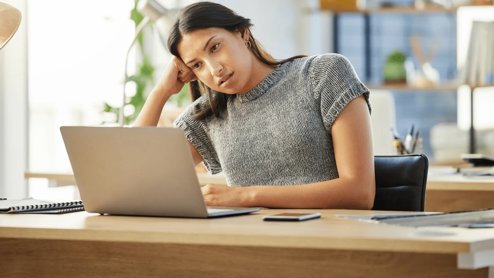 woman in gray shirt annoyed at laptop as she thinks i'm just going through the motions