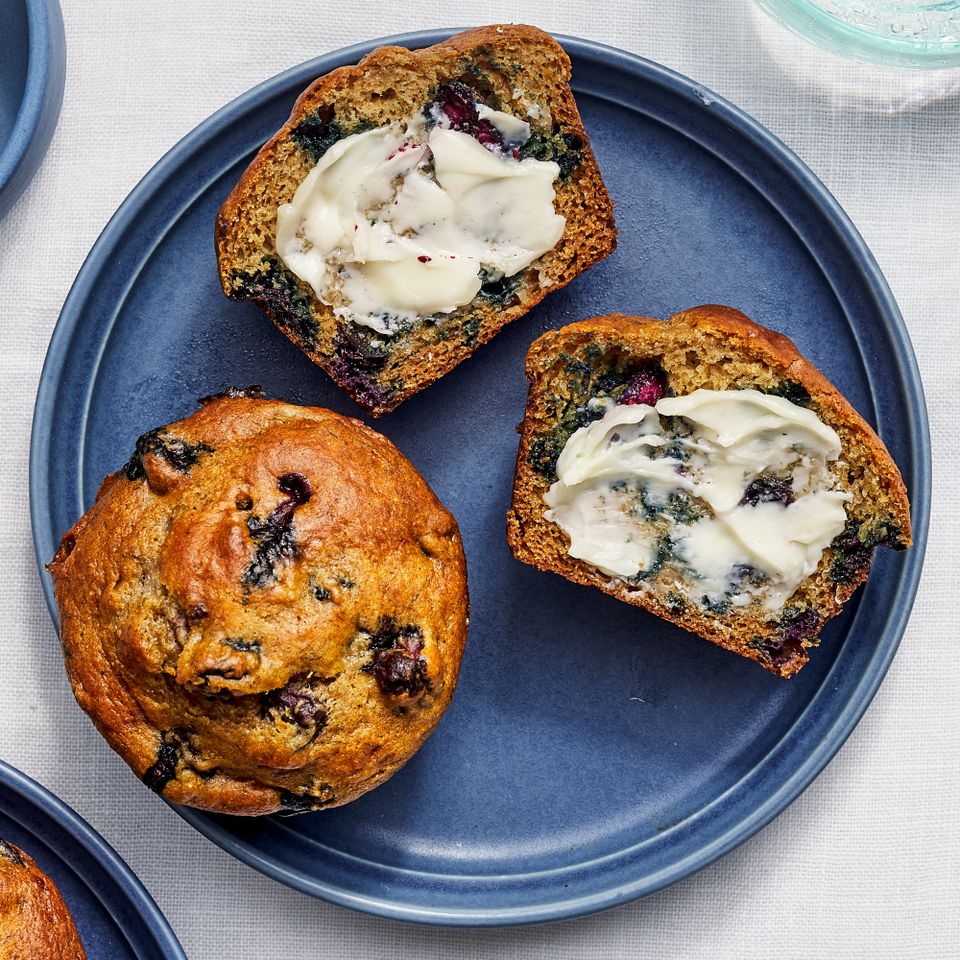 Overhead view of a blue plate of Banana-Blueberry Protein Muffins recipe with butter added Credit: Photographer: Fred Hardy, Food Stylist: Jennifer Wendorf, Prop Stylist: Julia Bayliss