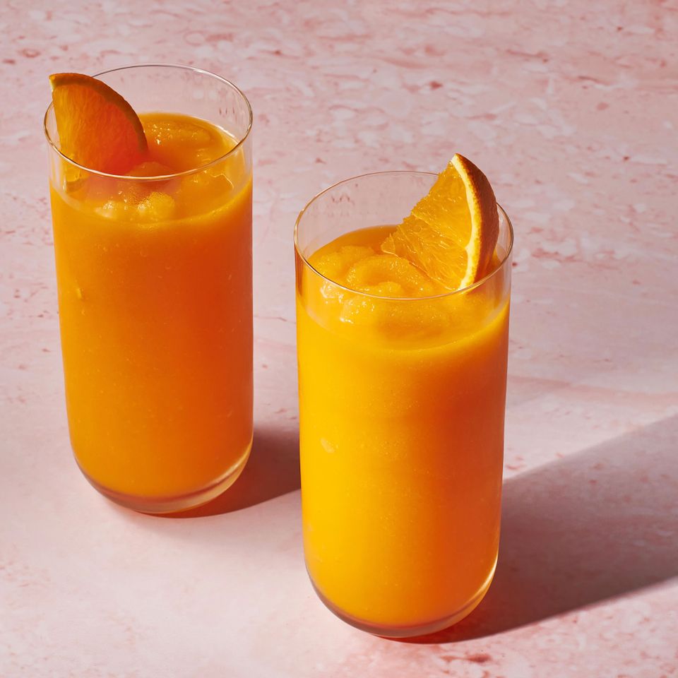 Two tall glasses filled with carrot smoothie, garnished with an orange wedge Credit: Diana Chistruga