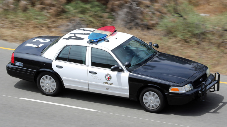 Crown Victoria Interceptor police car driving on a road