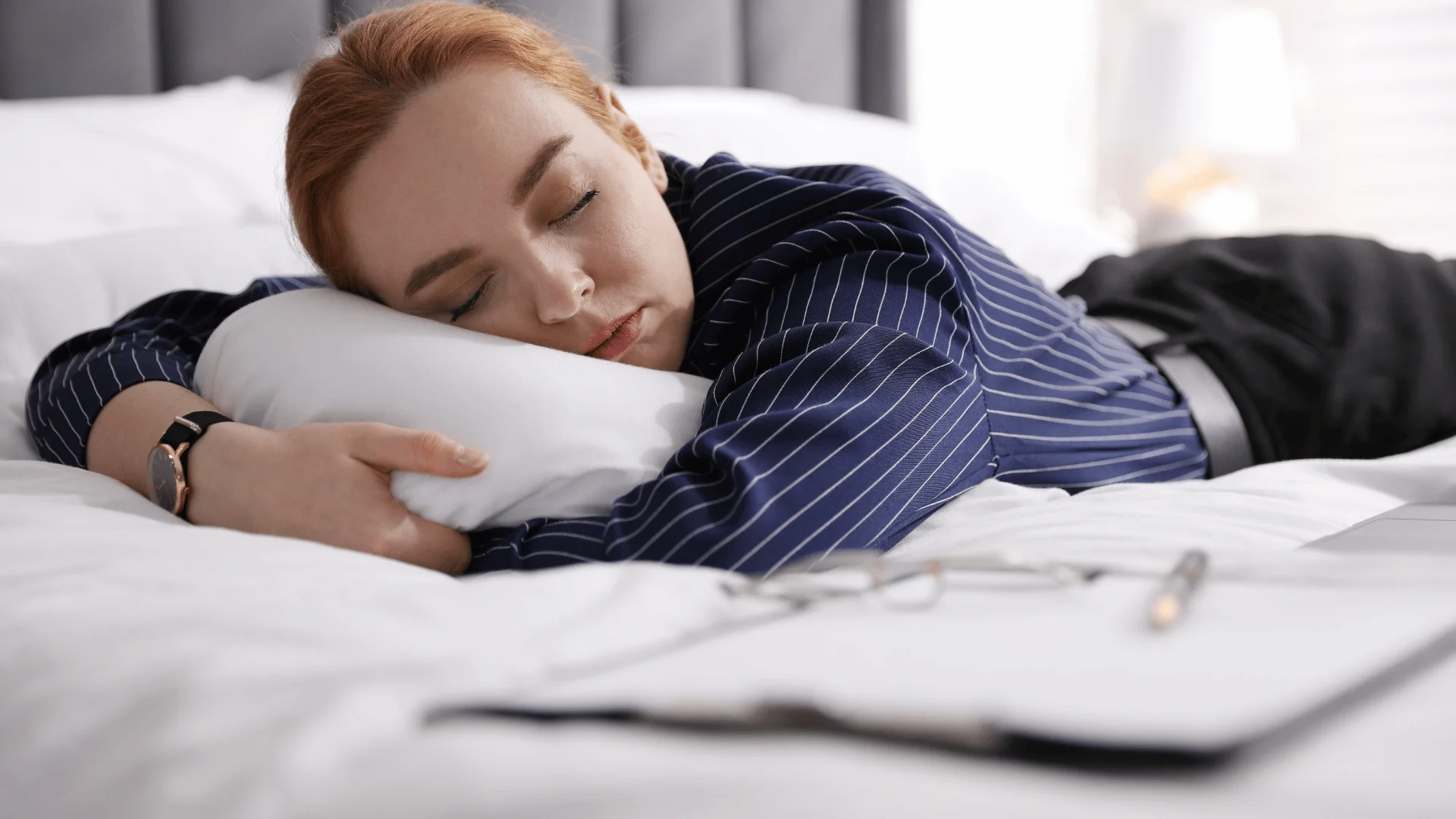 woman in navy blue shirt laying on the bed as she thinks i've been sleeping so much lately