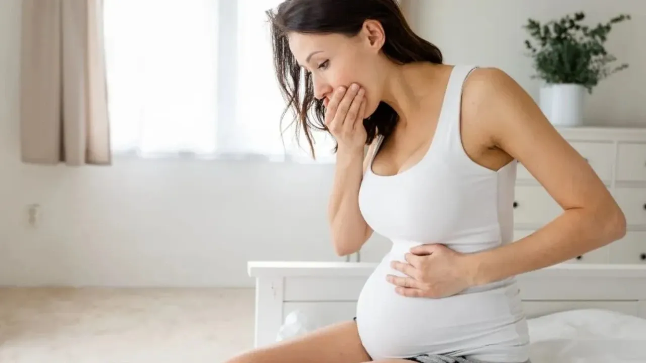 A woman is feeling nauseous while holding her stomach