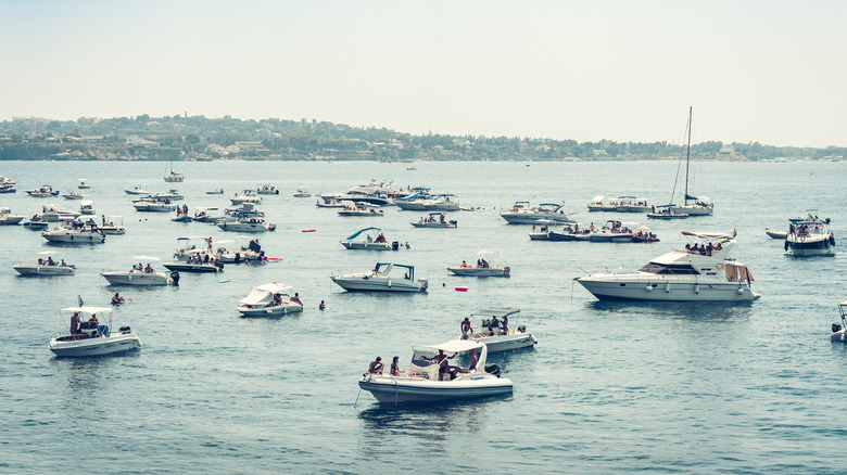A crowded harbor with several boats pictured.