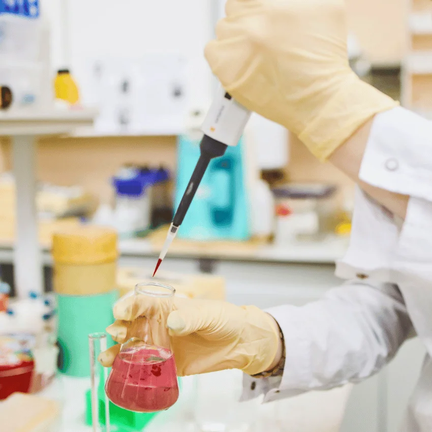 lab assistant holding pipette and beaker