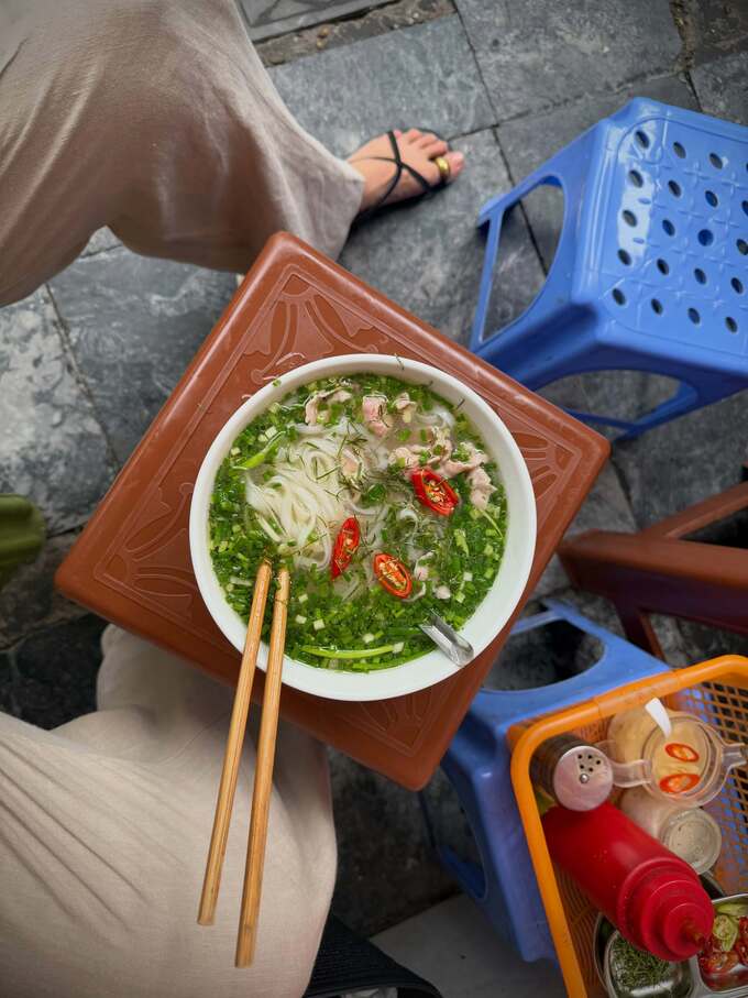 She experienced eating pho on a plastic chair on Hang Dieu street.