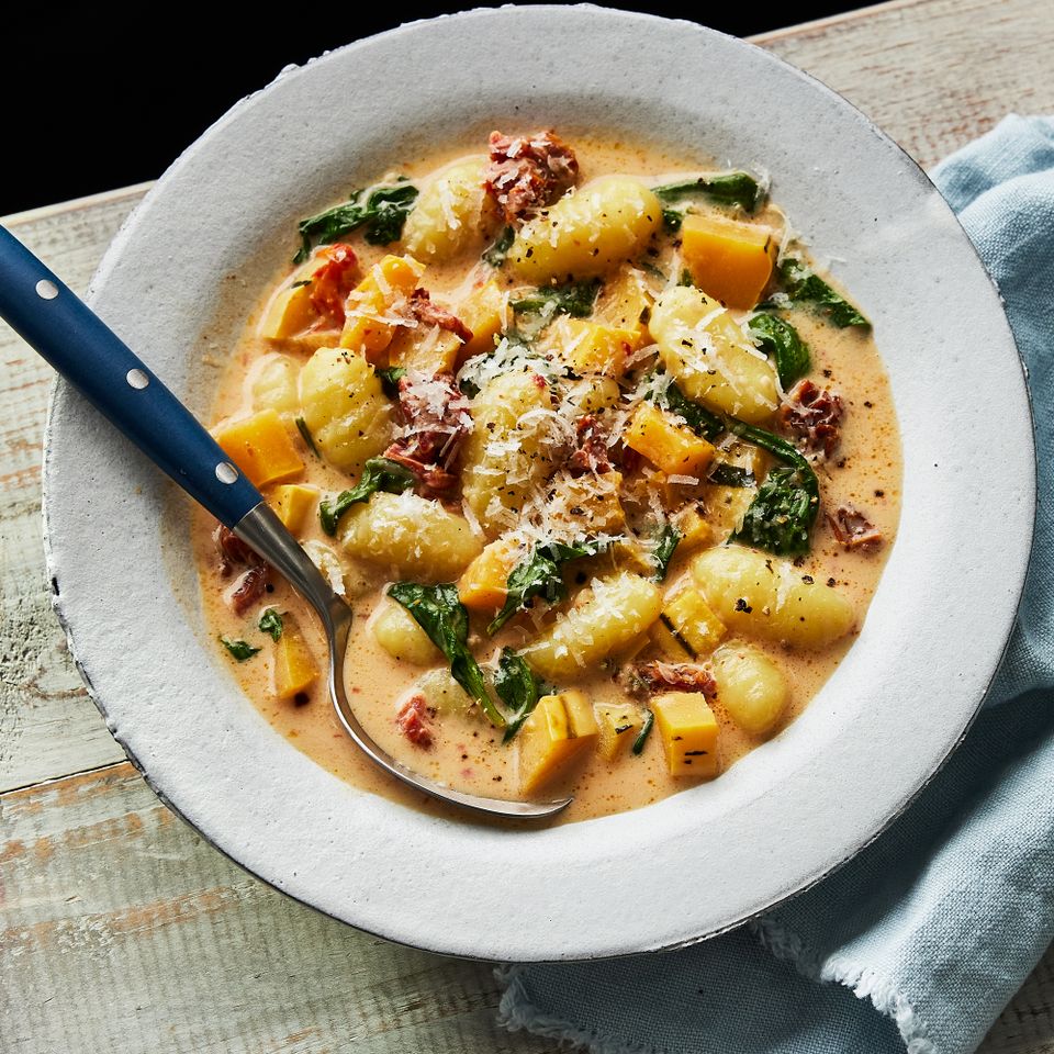 a recipe photo of the Slow-Cooker Creamy Sun-Dried Tomato Gnocchi with Delicata Squash & Spinach Credit: Photographer: Greg DuPree, Food Stylist: Ali Ramee Prop Stylist: Christine Keely