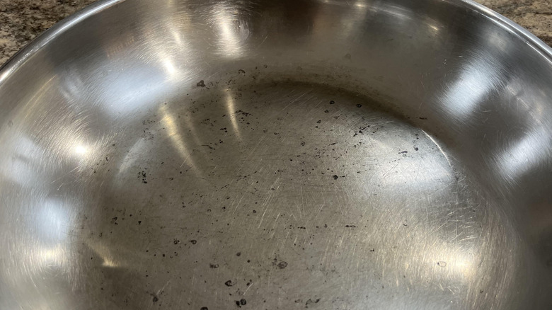 Close-up of a scuffed up stainless steel frying pan