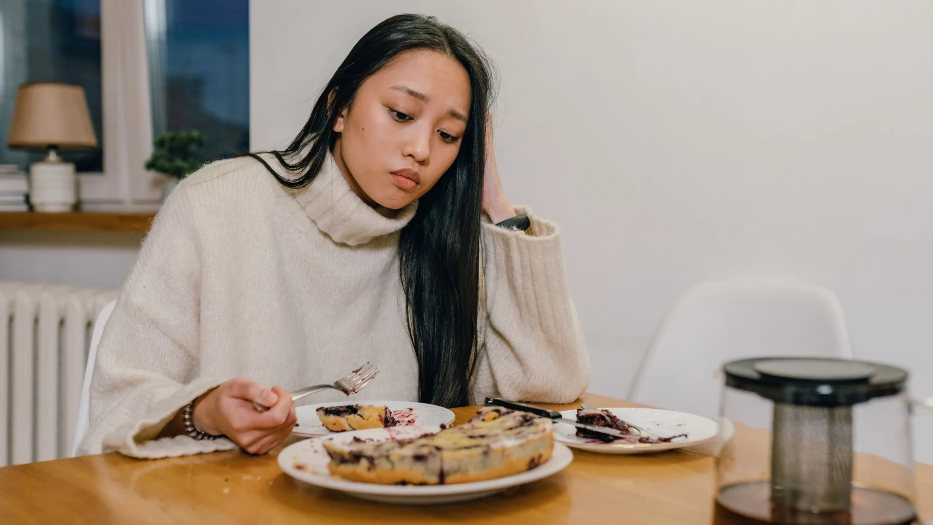 sad exhausted woman losing her appetite looking at food