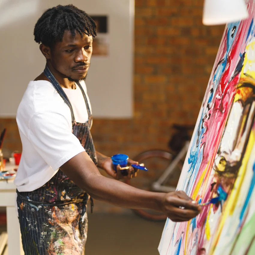 happy man disconnecting from work by painting instead of relying on his girlfriend as a distraction