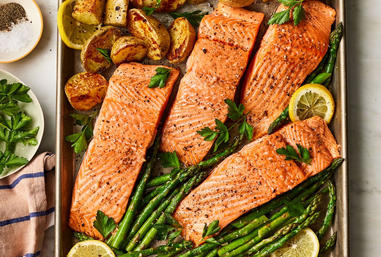 The Garlic Butter-Roasted Salmon with Potatoes & Asparagus recipe roasted on a sheet pan Credit: Photographer: Victor Protasio, Food Stylist: Margaret Dickey, Prop Stylist: Lydia Pursell